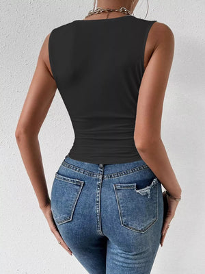 Black ruched cowl neck tank top with a cinched waist, paired with distressed denim jeans.