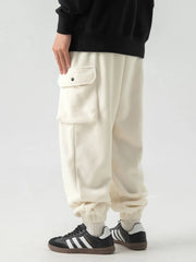 Ivory fleece cargo jogger trousers with a snap-button pocket detail.