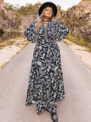 Dark navy paisley print tiered maxi dress with V-neck and long sleeves.