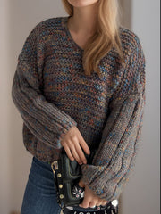 Textured knit sweater in dark gray with multicolor flecks, V-neck, balloon sleeves, and ribbed cuffs.
