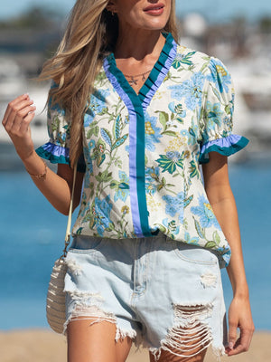 Floral frilled blouse with blue and green floral print, V-neck, short sleeves, and striped detail.