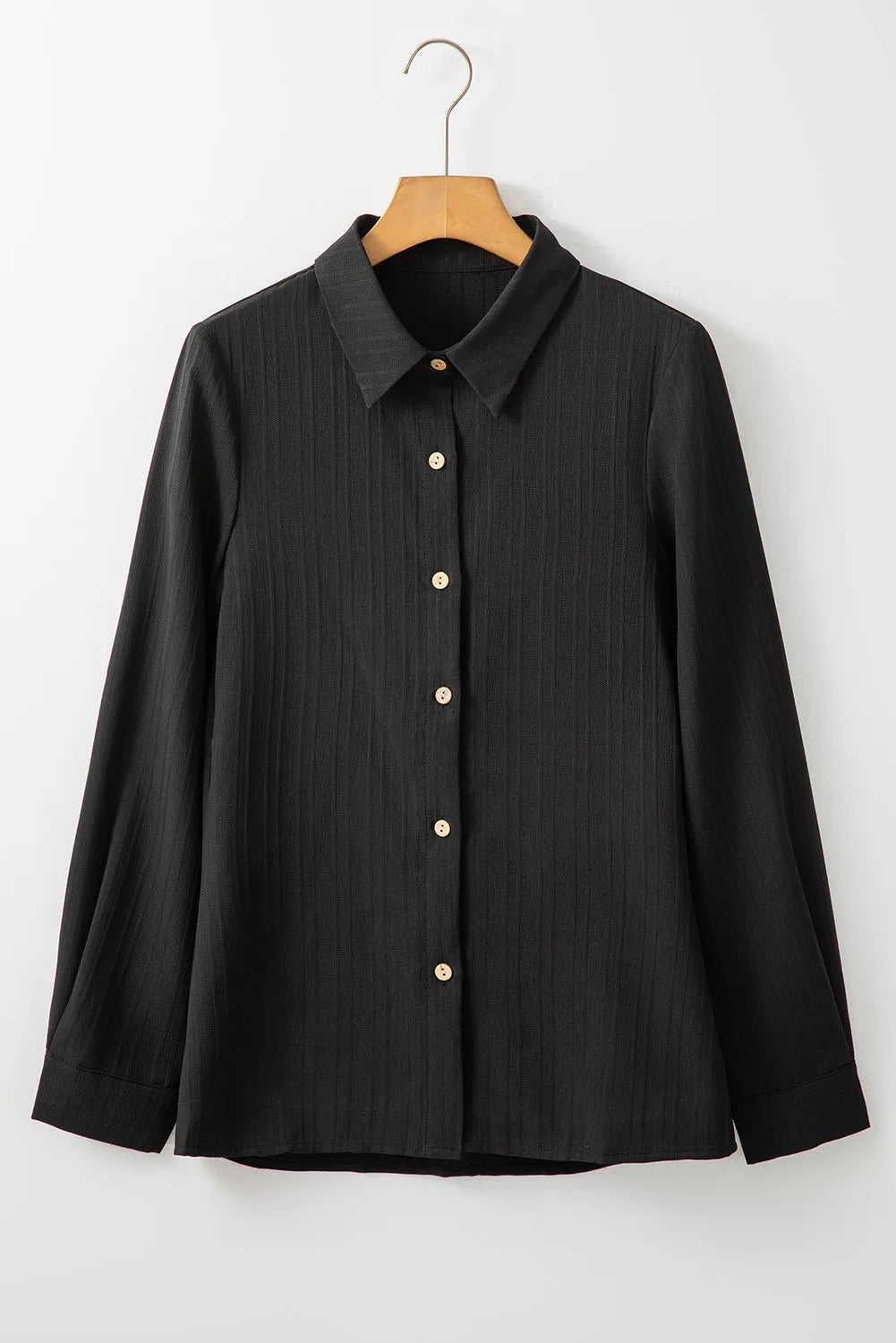 Black textured ribbed button-down shirt with a collared neckline and long sleeves.