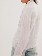 Light pink linen button-down blouse with ruffled placket and cuffed sleeves.