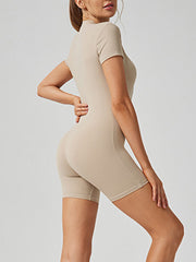 Sculpted tan short sleeve zip-front bodysuit with bike shorts.