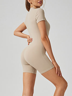 Sculpted tan short sleeve zip-front bodysuit with bike shorts.