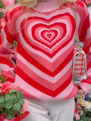 Heartbeat Stripe Mock Neck Knit sweater in pink and red with concentric heart pattern.