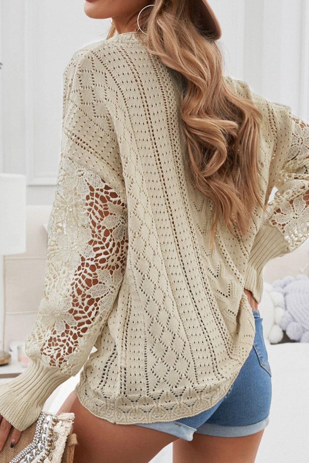 Beige openwork knit sweater with lace sleeves and diamond pattern detail.
