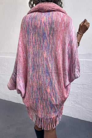 Textured knit cape in multi-color with faux fur collar and fringe hem.