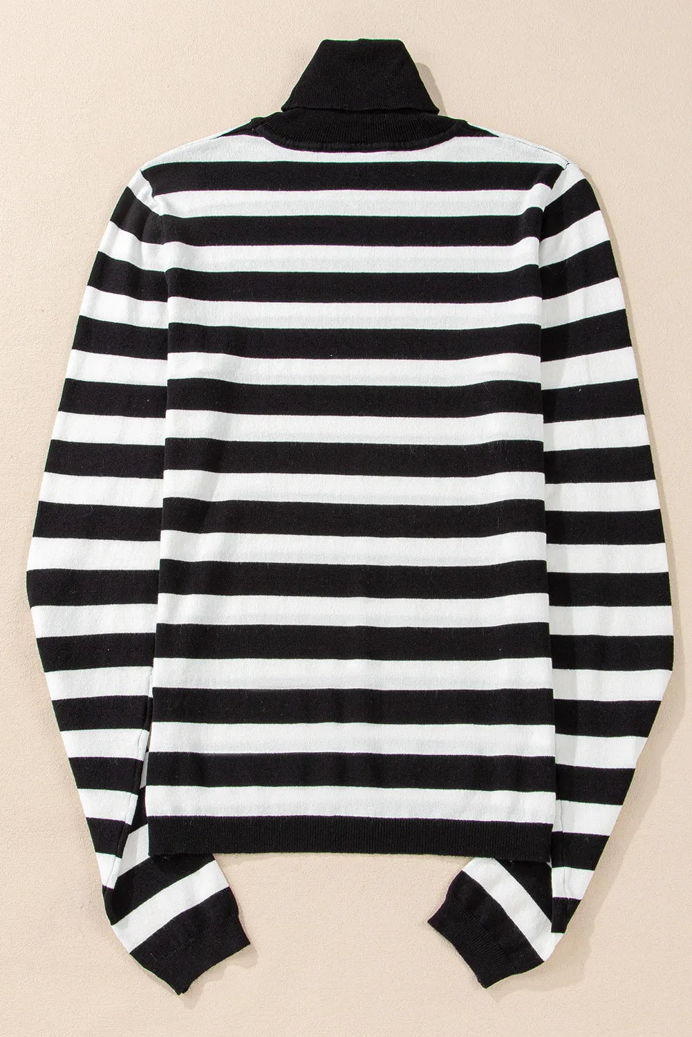 Graphic ribbed turtleneck top in black and white stripes with long sleeves.