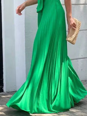 Green pleated maxi dress with tie-front detail and flowing skirt.