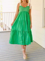 Green tiered midi dress with smocked bodice and tie shoulder straps.