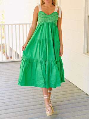 Green tiered midi dress with smocked bodice and tie shoulder straps.