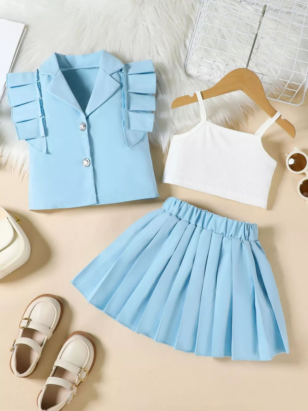 Blue collared ruffled sleeve jacket with white cami and pleated skirt.