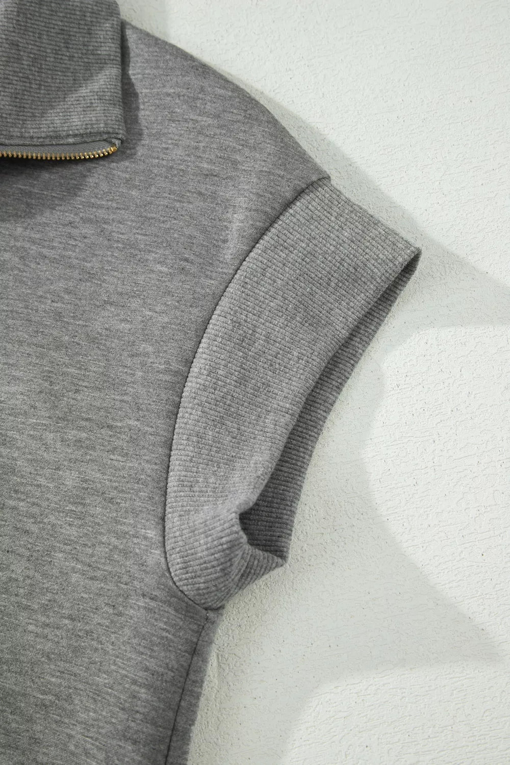 Chic dark gray half-zip polo top with ribbed cuffs and collar detail.