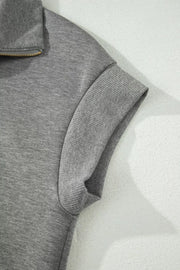 Chic dark gray half-zip polo top with ribbed cuffs and collar detail.