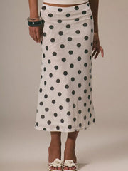 White midi skirt with black polka dots, sheer fabric, and a high waist.