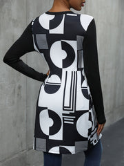 Black tunic top with asymmetric geometric print and long sleeves.