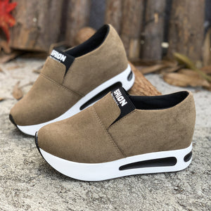 Dark brown round toe slip-on sneakers with white platform soles and black trim.