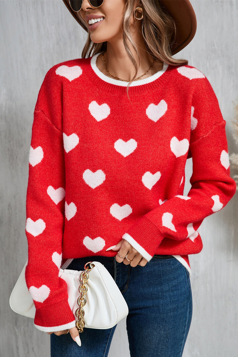 Red crewneck sweater with white heart intarsia pattern, long sleeves, and ribbed cuffs.
