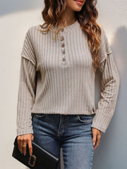 Tan textured henley shirt with button detail and flared sleeves.