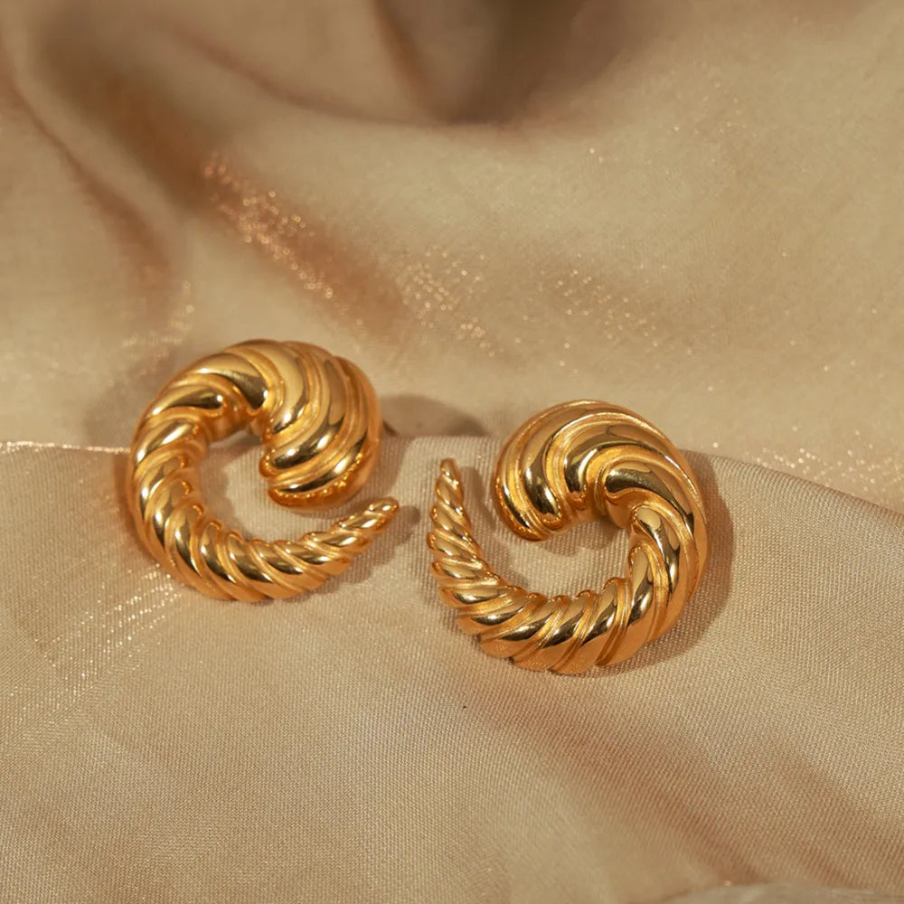 Gold sculptural swirl stud earrings with twisted texture detail