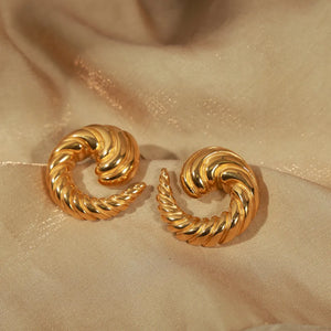 Gold sculptural swirl stud earrings with twisted texture detail