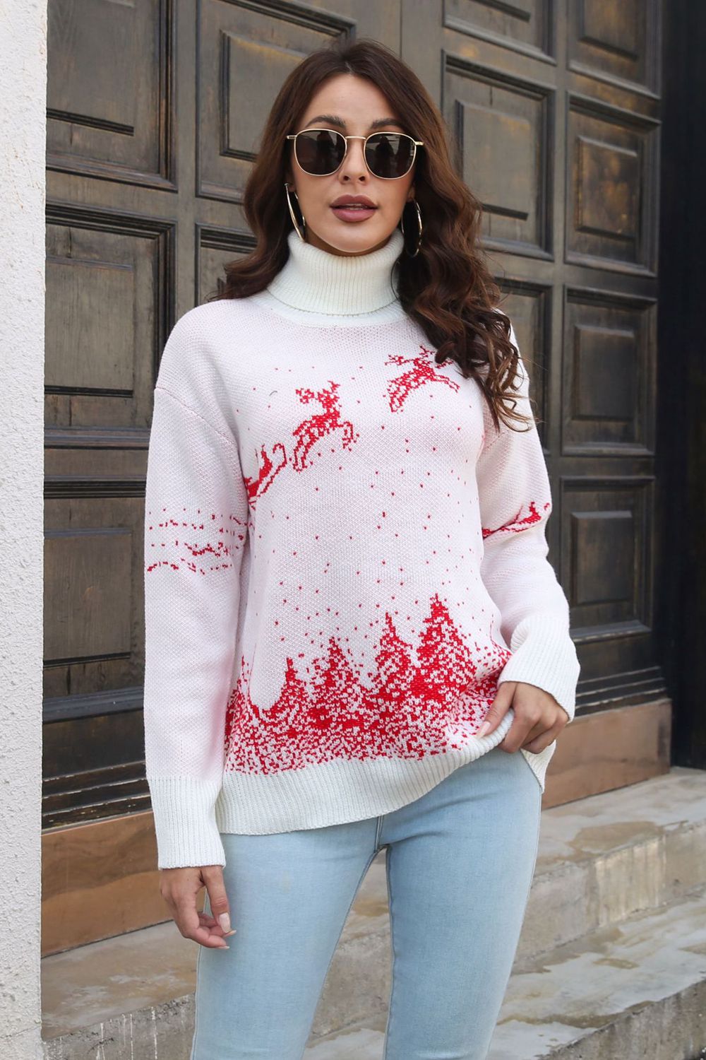 White turtleneck sweater with red reindeer and trees pattern, acrylic knit.