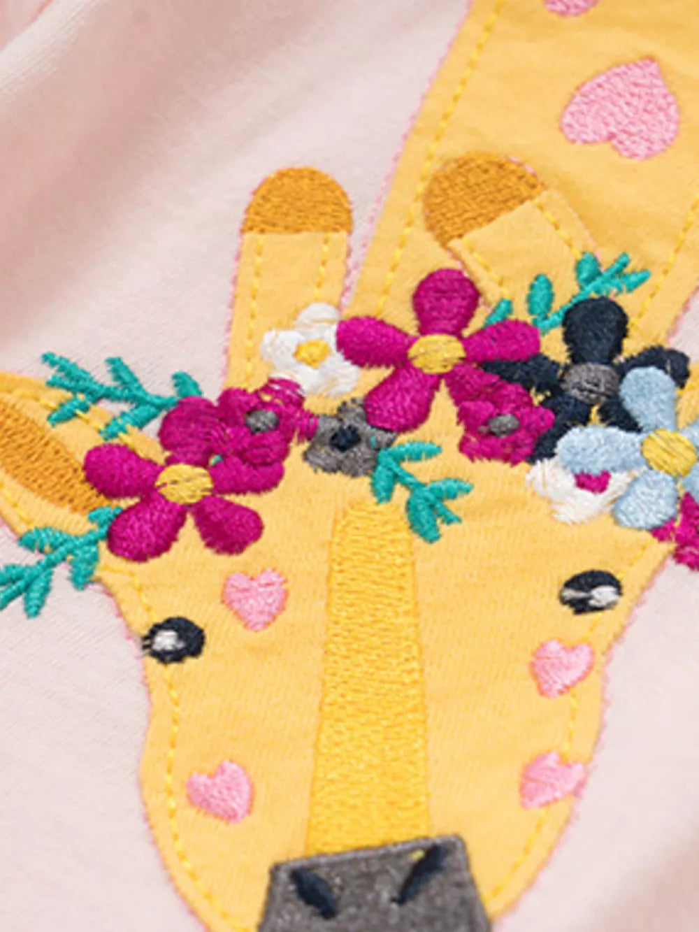 Pink cotton toddler t-shirt with a yellow giraffe embroidered face and colorful floral details.
