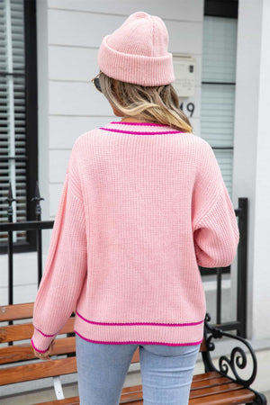 Pink acrylic cardigan with contrast trim and pockets, shown from the back.