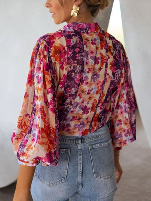 Vibrant floral print button-up shirt with bishop sleeves and a collared neckline.