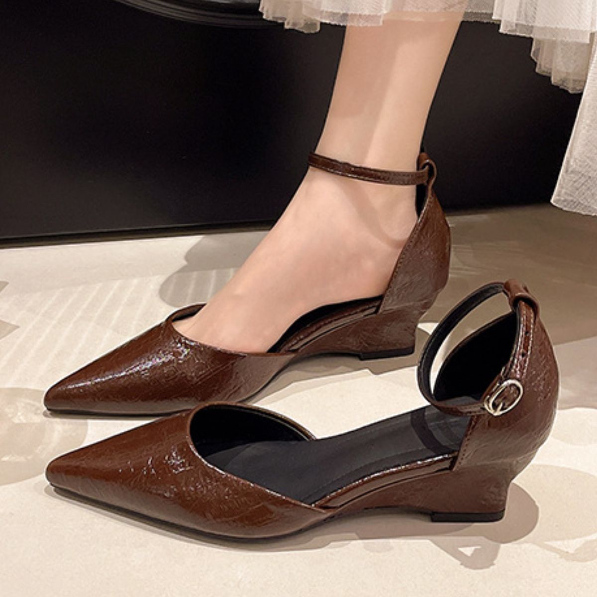 Brown pointed-toe ankle strap wedge shoes with adjustable buckle.