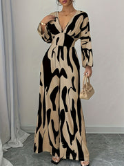 Abstract print wide leg jumpsuit with V-neck and long sleeves in beige and black.