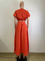 Orange crop top with puff sleeves and a high-waisted maxi skirt set.