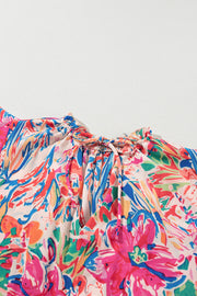 Floral blouse with tie-neck and flutter sleeves, featuring a vibrant abstract floral print.