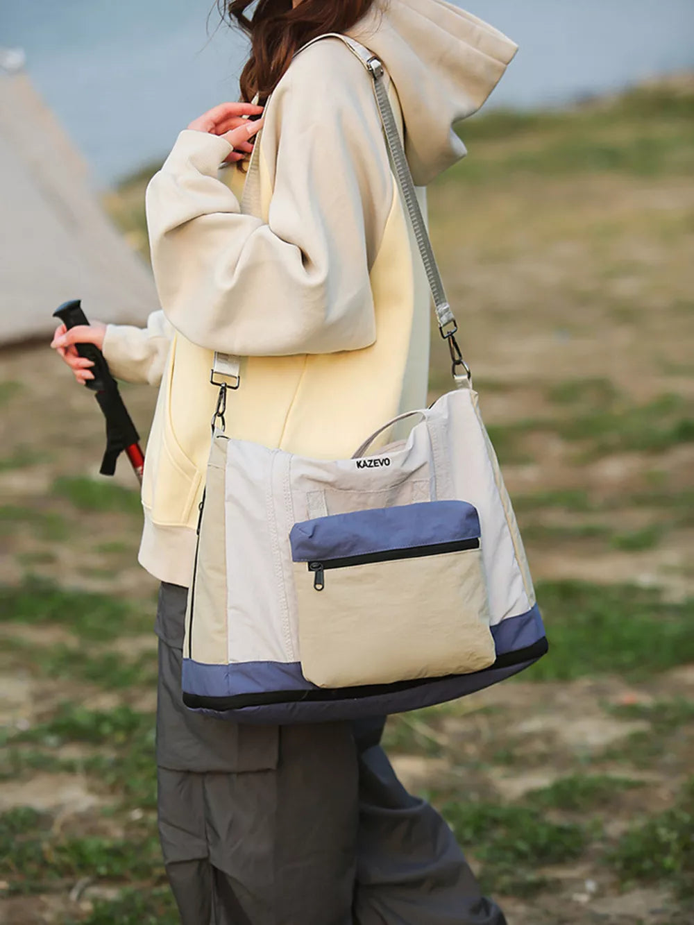 Chic nylon travel bag in beige and blue with multiple pockets and versatile carrying options.