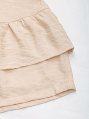 Tiered ruffle overlay shorts in tan with textured fabric detail.