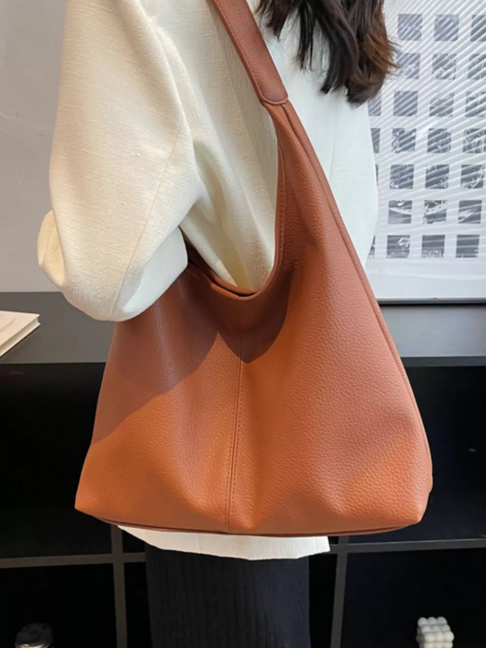 Brown pebbled leather hobo shoulder bag with a slouchy silhouette.