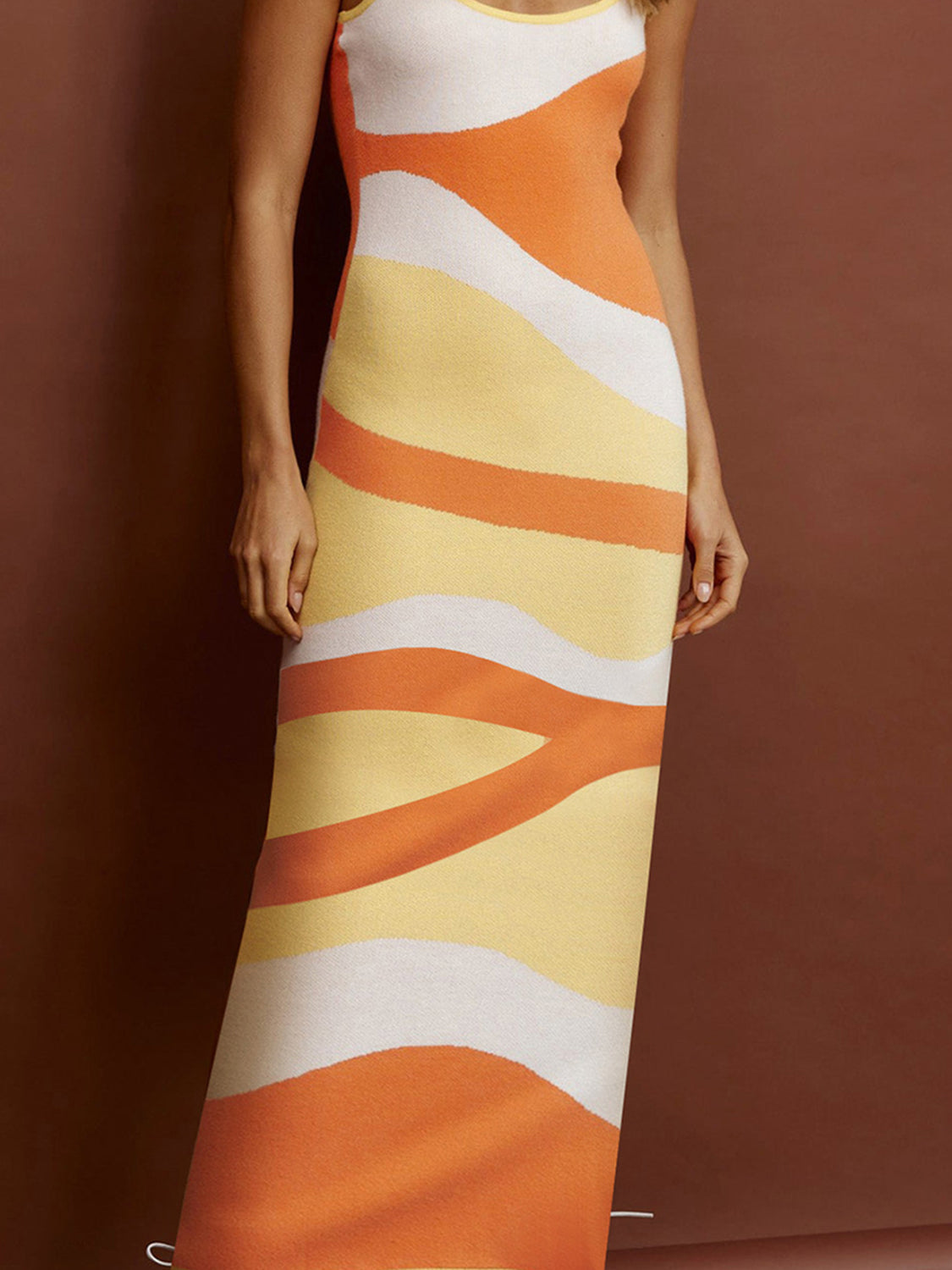 Geometric knit maxi slip dress in orange, yellow, and white abstract wavy stripes.