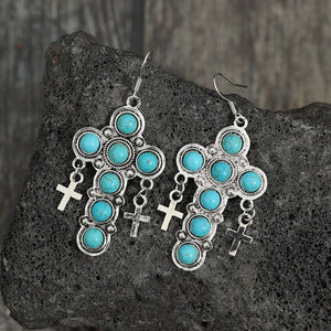 Southwestern turquoise cross dangle earrings with silver alloy crosses.