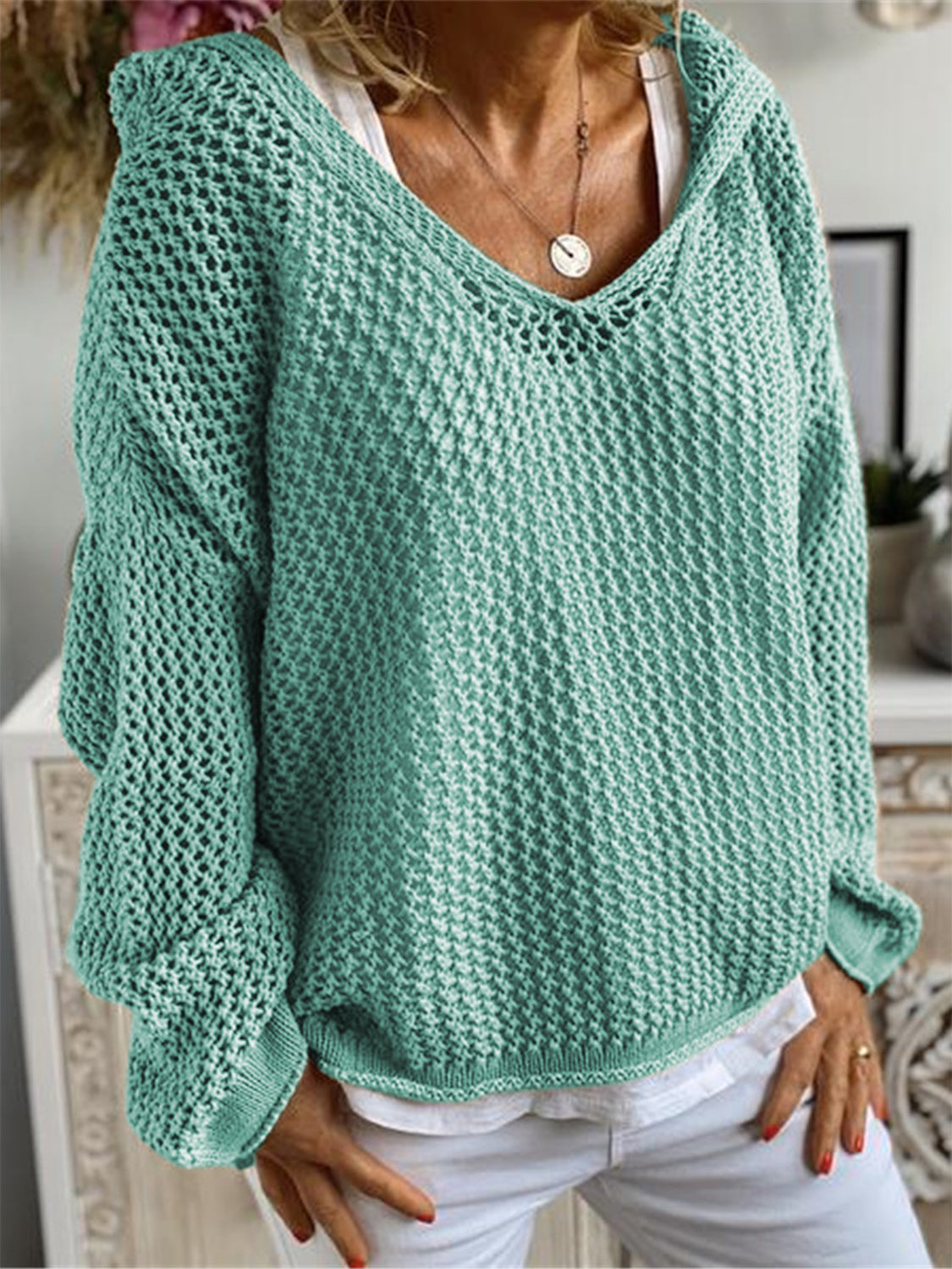 Turquoise open-knit slouchy hooded sweater with a deep V-neck and long sleeves.