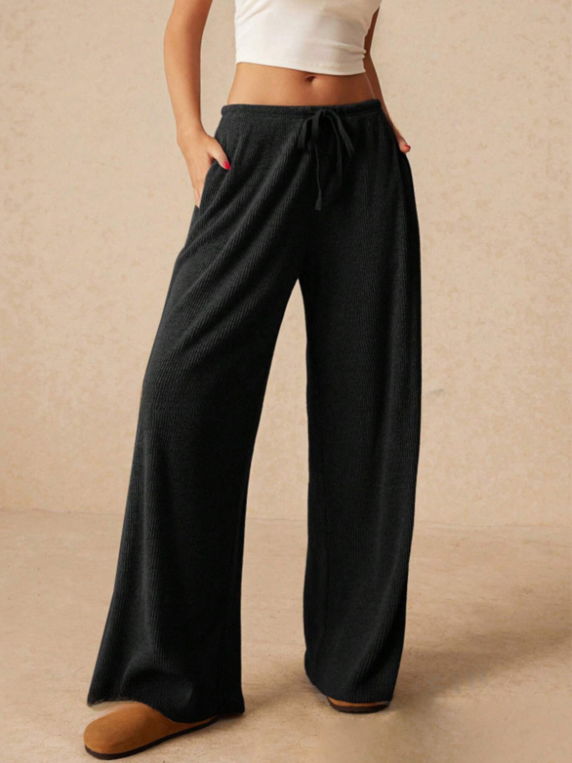 Black ribbed palazzo lounge trousers with drawstring waist and wide legs.