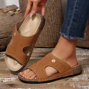 Perforated brown pu leather wedge sandals with open toe and decorative button detail.