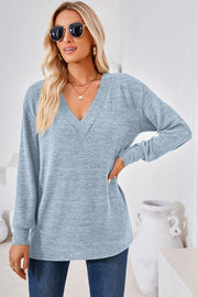 Light blue relaxed V-neck tunic top with long sleeves and a textured knit.