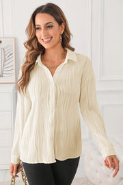 Beige oversized button-down shirt with a textured pleated design and long sleeves.