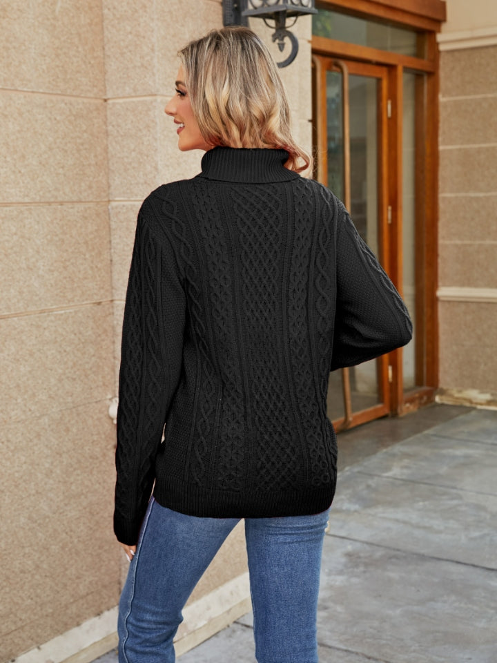 Black cable knit turtleneck sweater with textured pattern.