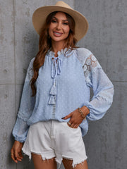 Textured Misty Blue tie-neck blouse with lace trim and tassels.