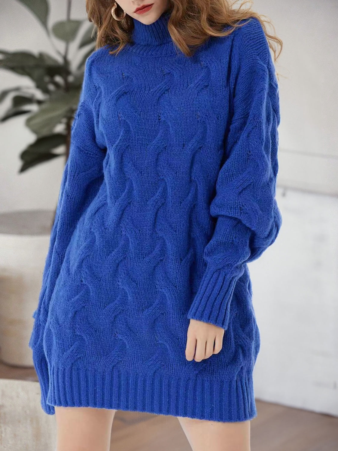 Royal blue cable knit turtleneck mini dress with long sleeves and ribbed cuffs.