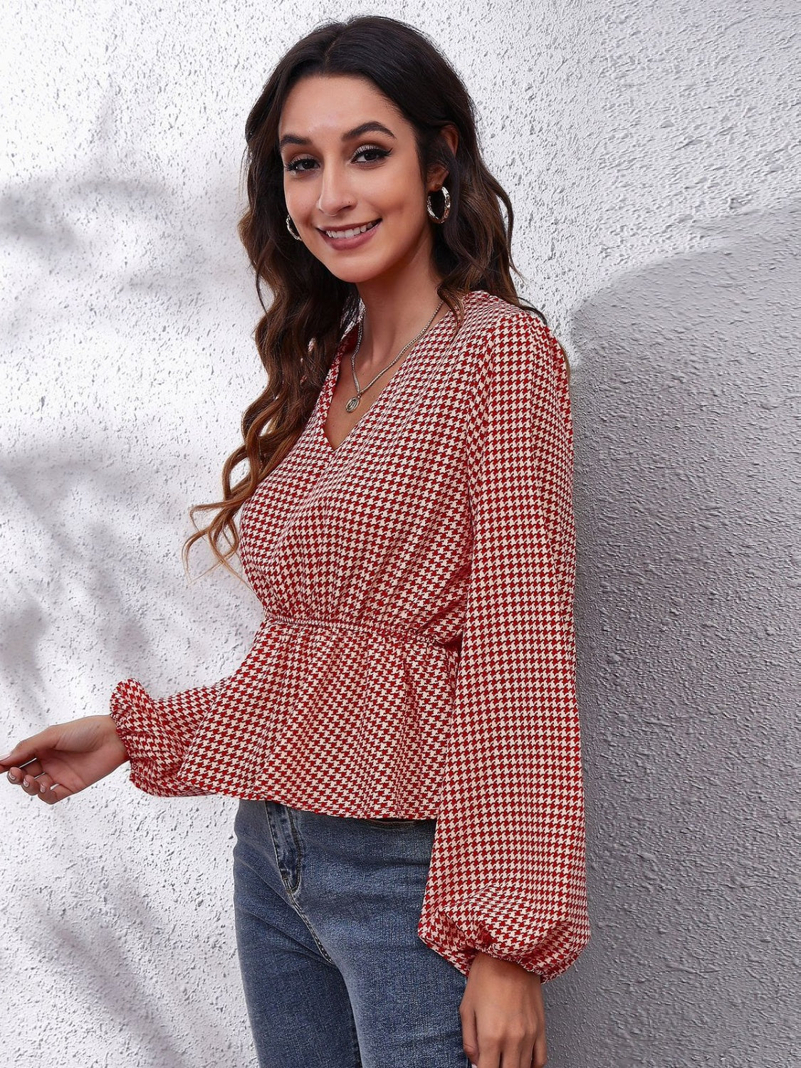 Gingham peplum blouse with gathered waist in red and white, featuring a V-neck and balloon sleeves.