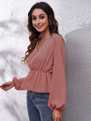 Gingham peplum blouse with gathered waist in red and white, featuring a V-neck and balloon sleeves.