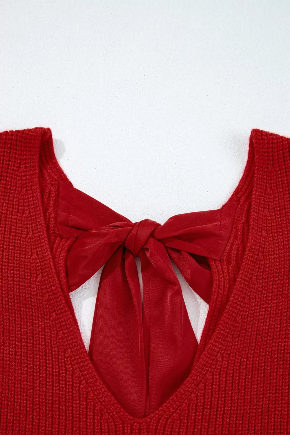 Red knit sweater with backless detail and satin bow tie closure